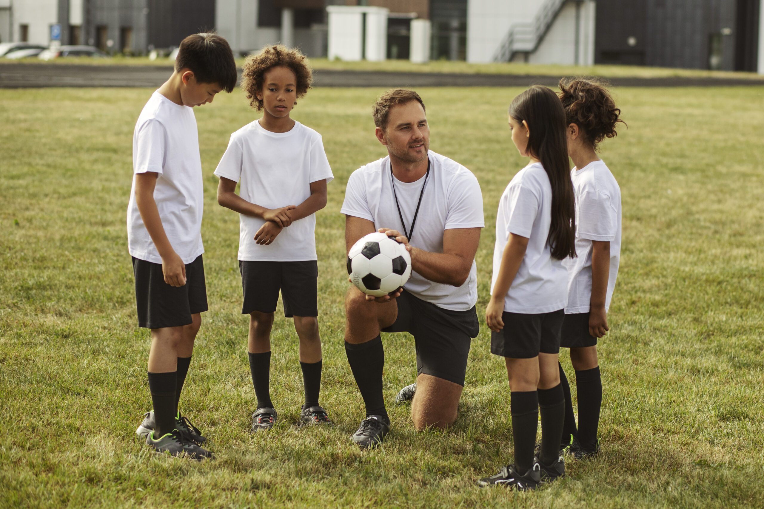 kids-playing-football-supervised-by-football-trainer